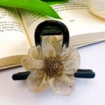 گیره مو گل طلایی روی کتاب باز