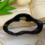 گل و کلیپس در کنار کتاب باز