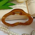 گیره موی قهوه‌ای روی کتاب باز
